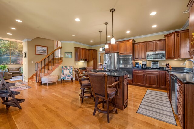 101 Sand Piper Ct, Midway, KY 40347 - kitchen featuring appliances with stainless steel finishes, crown molding, a sink, a kitchen island, and light wood-type flooring