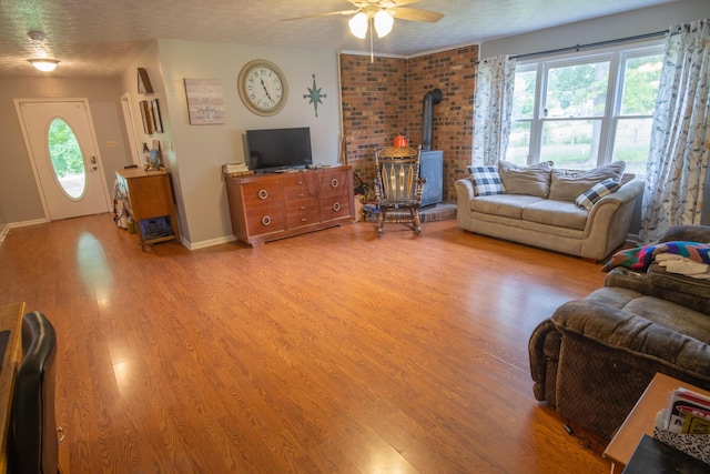 1987 White Rock Rd, Mount Vernon, KY 40456 - living room featuring a wood stove, ceiling fan, light wood-style flooring, healthy amount of natural light, and a textured ceiling