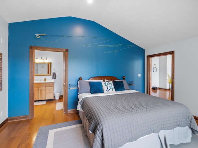 389 Lakeview Dr, Somerset, KY 42503 - bedroom featuring wood finished floors, lofted ceiling, baseboards, ensuite bathroom, and a sink