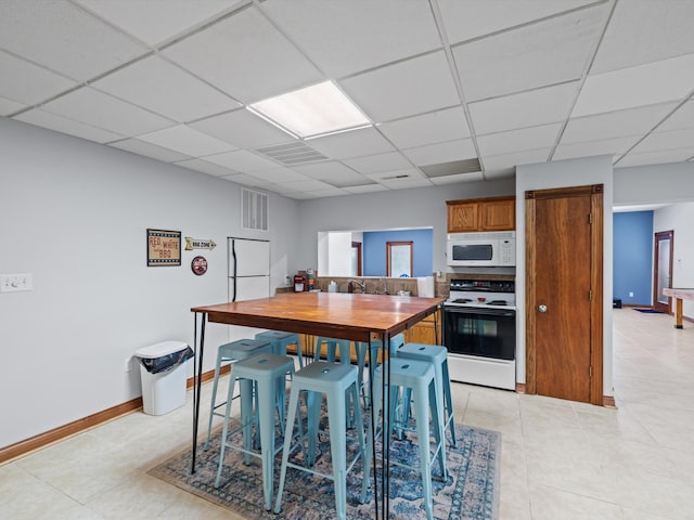 389 Lakeview Dr, Somerset, KY 42503 - kitchen with white appliances, a paneled ceiling, brown cabinetry, baseboards, and a sink