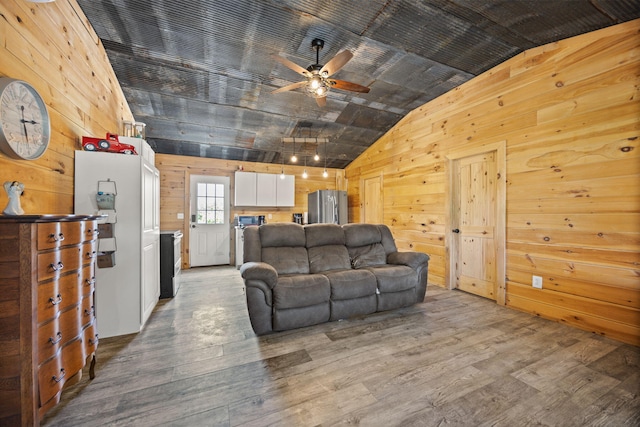 3402 Roundtop Rd, Strunk, KY 42649 - living area with vaulted ceiling, wood walls, ceiling fan, and light wood-style floors