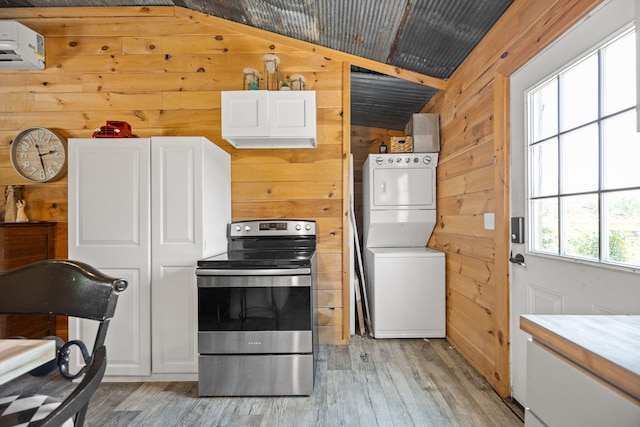 3402 Roundtop Rd, Strunk, KY 42649 - kitchen featuring stainless steel electric range, stacked washing machine and dryer, wood walls, light wood-style flooring, and lofted ceiling
