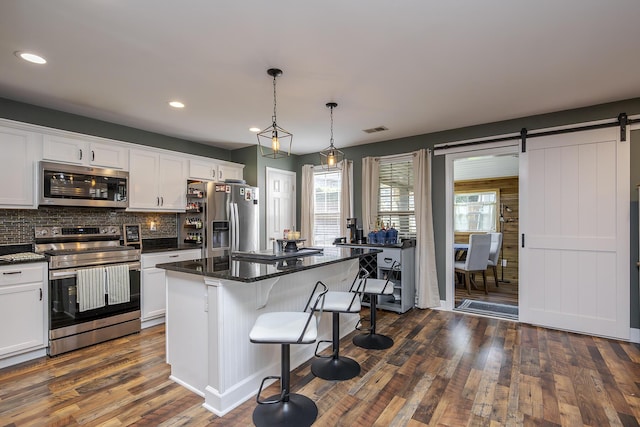 701 Sprucewood Dr, Lexington, KY 40514 - kitchen with stainless steel appliances, white cabinetry, backsplash, dark wood-style flooring, and a kitchen island