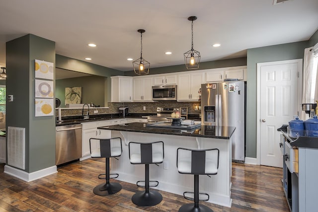 701 Sprucewood Dr, Lexington, KY 40514 - kitchen with stainless steel appliances, dark wood-style flooring, white cabinets, a kitchen island, and tasteful backsplash