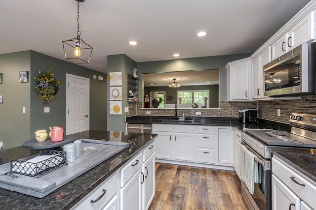 701 Sprucewood Dr, Lexington, KY 40514 - kitchen featuring appliances with stainless steel finishes, a sink, dark wood-style floors, tasteful backsplash, and white cabinets