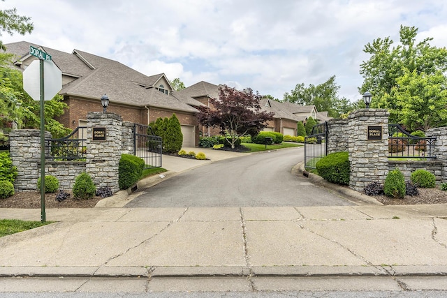 3519 Doral Pl, Lexington, KY 40509 - view of asphalt road featuring street lights, curbs, a gate, and traffic signs