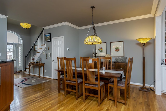 3519 Doral Pl, Lexington, KY 40509 - dining area featuring light wood-style floors, crown molding, stairs, and baseboards