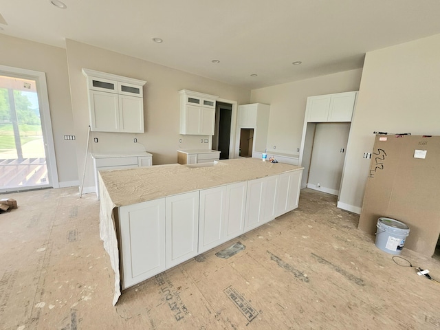 202 The Backstretch, Nicholasville, KY 40356 - kitchen featuring white cabinetry, a spacious island, recessed lighting, glass insert cabinets, and light stone countertops