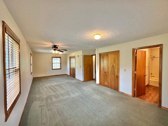 7532 Maysville Rd, Carlisle, KY 40311 - unfurnished bedroom with carpet, baseboards, multiple closets, a textured ceiling, and ensuite bath