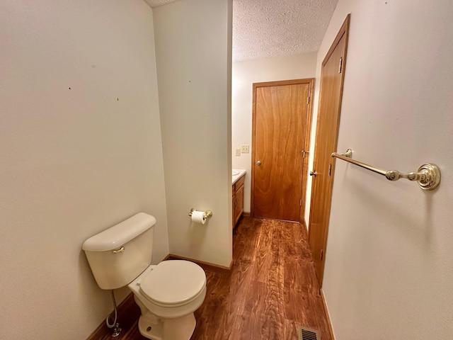 7532 Maysville Rd, Carlisle, KY 40311 - half bathroom with vanity, toilet, wood finished floors, a textured ceiling, and baseboards