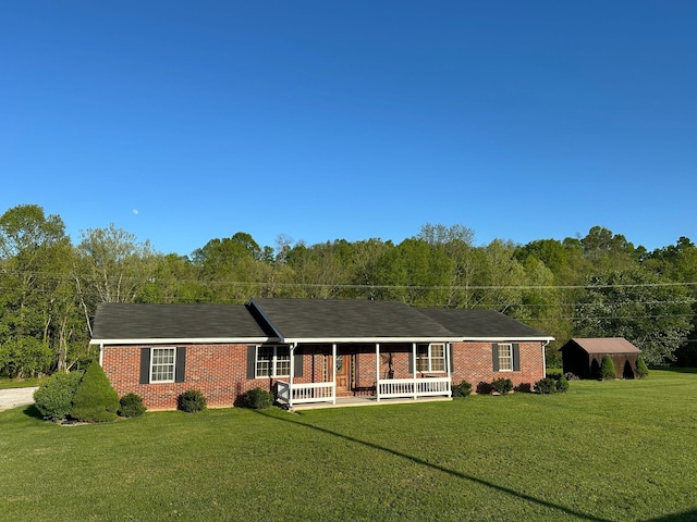 7532 Maysville Rd, Carlisle, KY 40311 - ranch-style home with covered porch, a front lawn, brick siding, and a view of trees