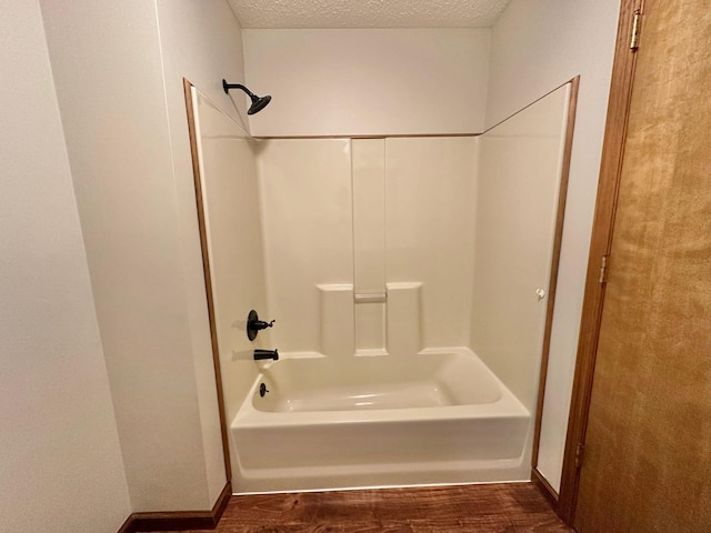 7532 Maysville Rd, Carlisle, KY 40311 - bathroom featuring wood finished floors,  shower combination, a textured ceiling, and baseboards