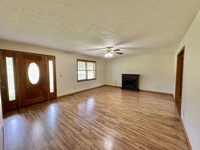 7532 Maysville Rd, Carlisle, KY 40311 - unfurnished living room featuring light wood-style floors, a ceiling fan, a textured ceiling, and baseboards