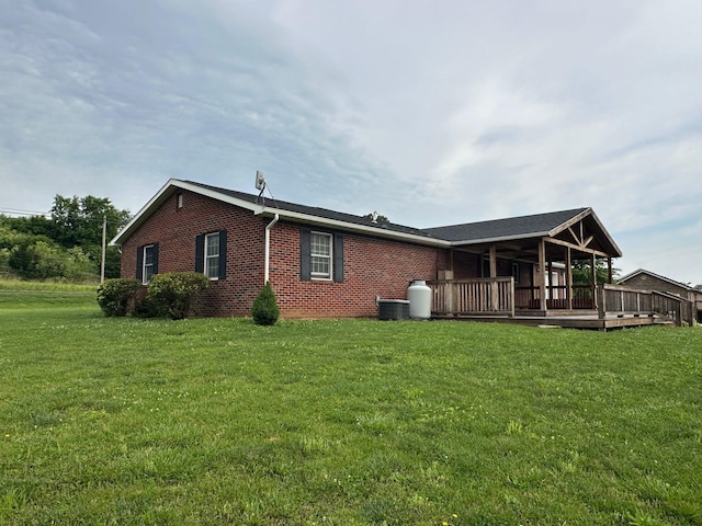 7532 Maysville Rd, Carlisle, KY 40311 - rear view of house featuring a lawn, brick siding, a wooden deck, and central AC