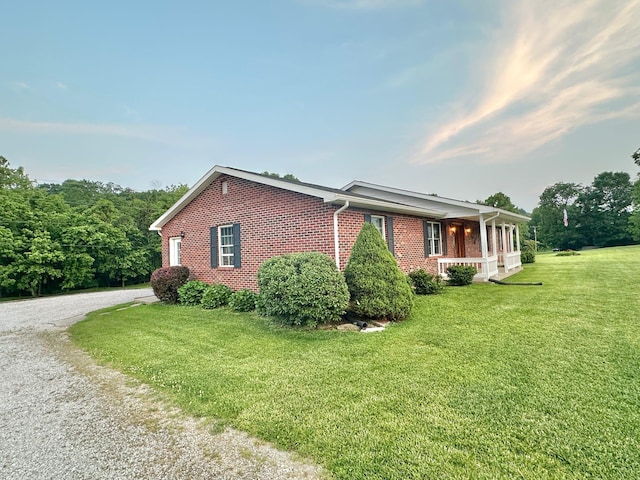 7532 Maysville Rd, Carlisle, KY 40311 - view of side of property with brick siding, a yard, driveway, and a porch