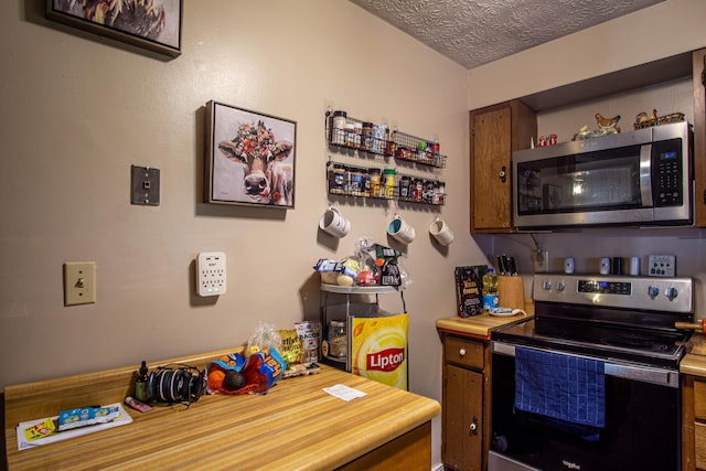 1540 Stoney Fork Rd, Corbin, KY 40701 - kitchen featuring appliances with stainless steel finishes, light countertops, a textured ceiling, open shelves, and brown cabinets