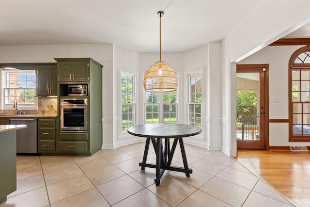 2128 Leafland Pl, Lexington, KY 40515 - kitchen featuring appliances with stainless steel finishes, a sink, light tile patterned flooring, tasteful backsplash, and green cabinets