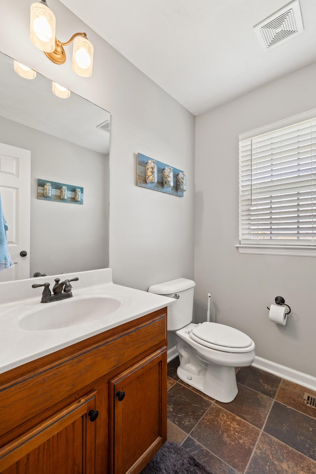 962 Cobble Dr, Richmond, KY 40475 - half bathroom featuring vanity, toilet, baseboards, and stone tile flooring