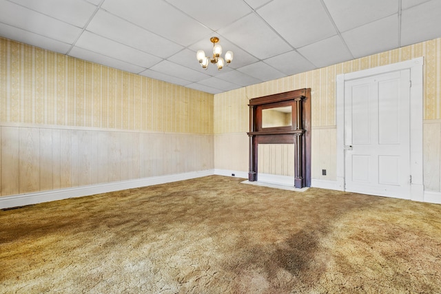 522 Atwood St, Louisville, KY 40217 - spare room featuring a paneled ceiling, wallpapered walls, carpet flooring, a wainscoted wall, and a chandelier