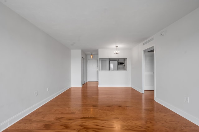 2121 Nicholasville Rd Unit 910, Lexington, KY 40503 - unfurnished living room featuring a chandelier, wood finished floors, and baseboards