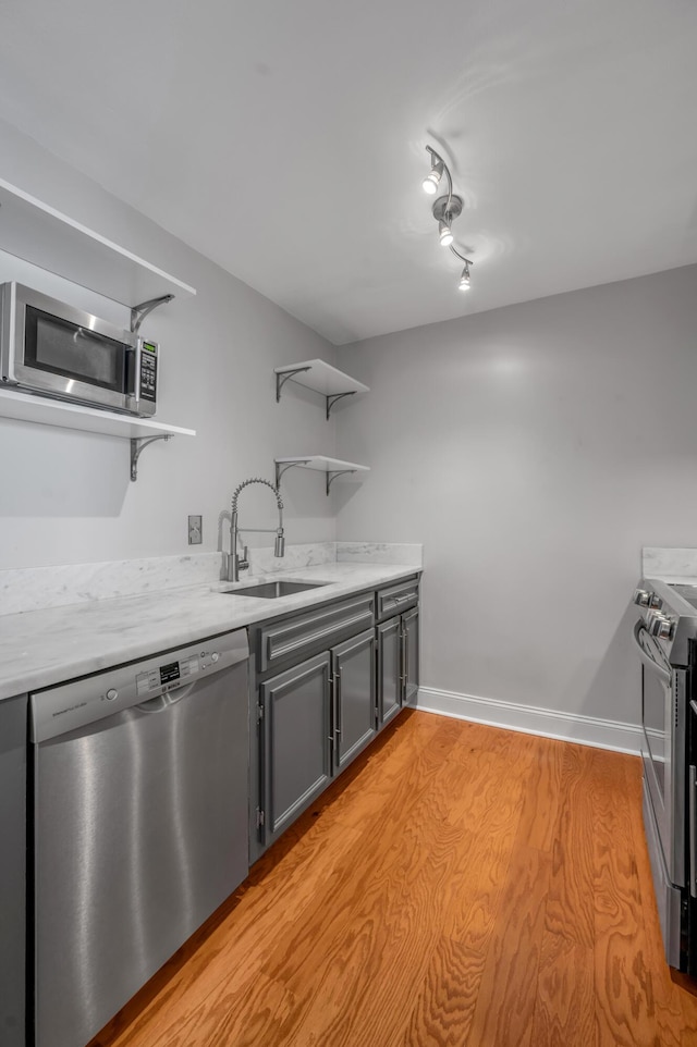 2121 Nicholasville Rd Unit 910, Lexington, KY 40503 - kitchen featuring open shelves, stainless steel appliances, a sink, light countertops, and light wood-style flooring