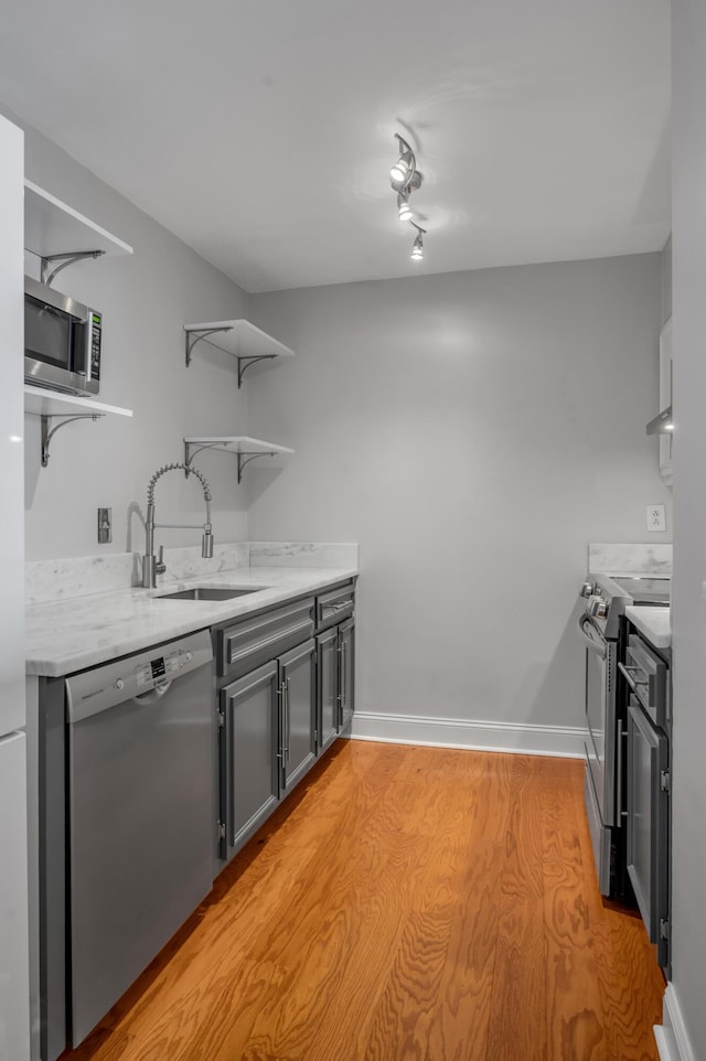 2121 Nicholasville Rd Unit 910, Lexington, KY 40503 - kitchen with appliances with stainless steel finishes, open shelves, a sink, light wood-style flooring, and baseboards