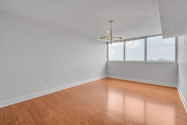2121 Nicholasville Rd Unit 910, Lexington, KY 40503 - empty room featuring wood finished floors, a chandelier, and baseboards