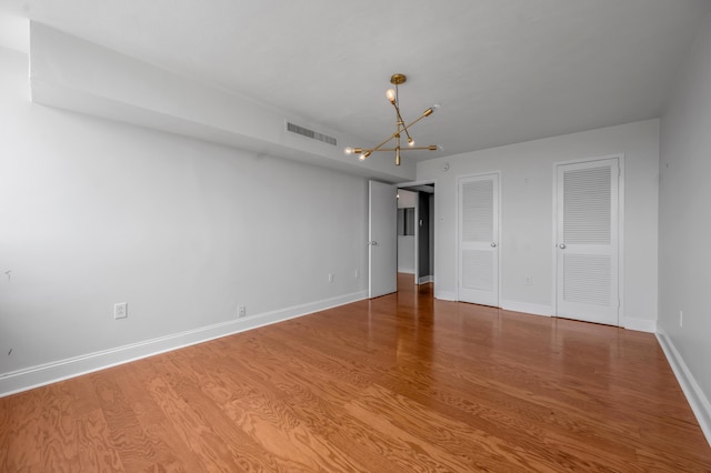 2121 Nicholasville Rd Unit 910, Lexington, KY 40503 - unfurnished bedroom with a chandelier, two closets, wood finished floors, and baseboards