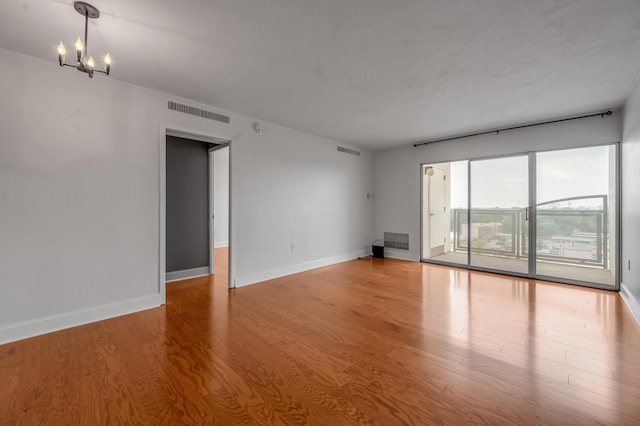 2121 Nicholasville Rd Unit 910, Lexington, KY 40503 - unfurnished room featuring wood finished floors, baseboards, and a chandelier