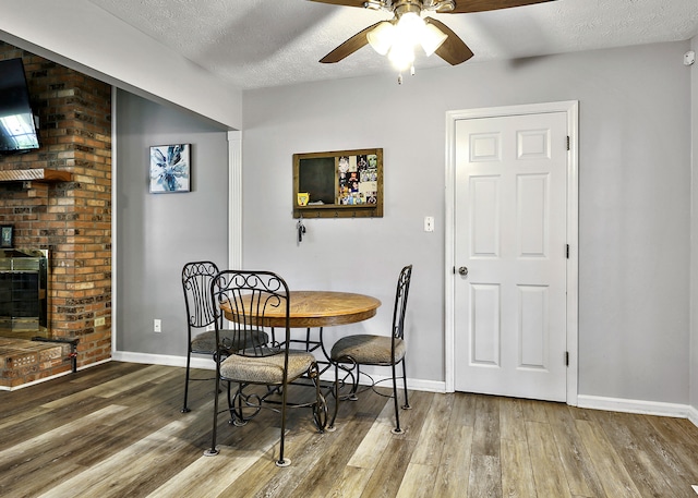 400 Aspen Dr, Lawrenceburg, KY 40342 - dining space with wood finished floors, ceiling fan, a textured ceiling, and a brick fireplace
