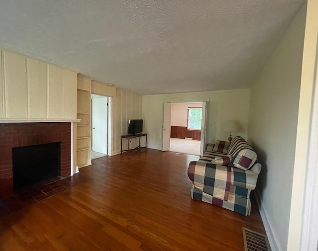 411 Ohara Dr, Danville, KY 40422 - living area with dark wood finished floors, a textured ceiling, and a brick fireplace