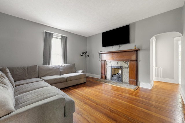 611 Old Shakertown Rd, Danville, KY 40422 - living area featuring arched walkways, a fireplace, baseboards, and wood finished floors