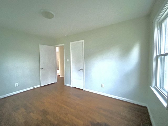 324 Glendale Ave, Lexington, KY 40511 - unfurnished bedroom featuring baseboards, multiple windows, and dark wood-style floors
