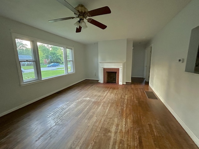 324 Glendale Ave, Lexington, KY 40511 - unfurnished living room featuring wood finished floors, ceiling fan, baseboards, and a brick fireplace