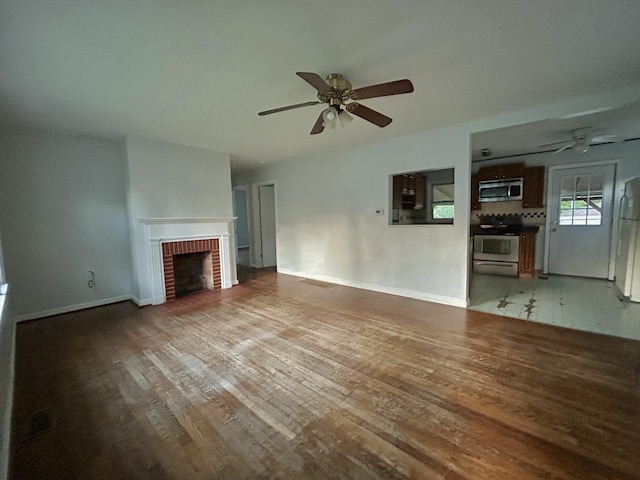 324 Glendale Ave, Lexington, KY 40511 - unfurnished living room featuring a ceiling fan, wood finished floors, a fireplace, and baseboards