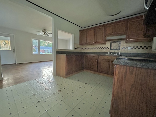 324 Glendale Ave, Lexington, KY 40511 - kitchen with dark countertops, a sink, ceiling fan, tasteful backsplash, and light floors