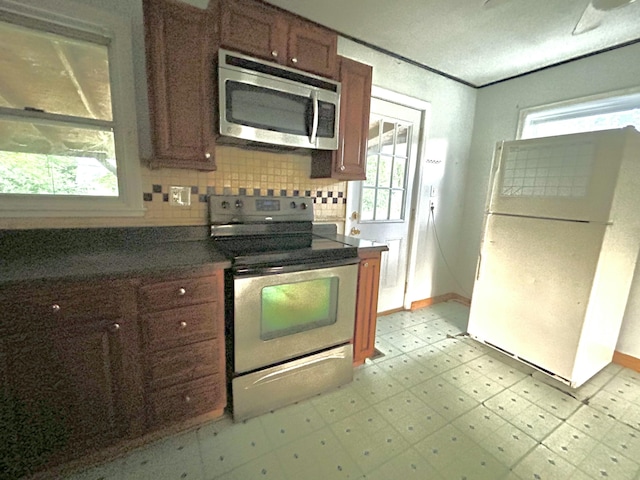 324 Glendale Ave, Lexington, KY 40511 - kitchen with stainless steel appliances, light floors, baseboards, backsplash, and dark countertops