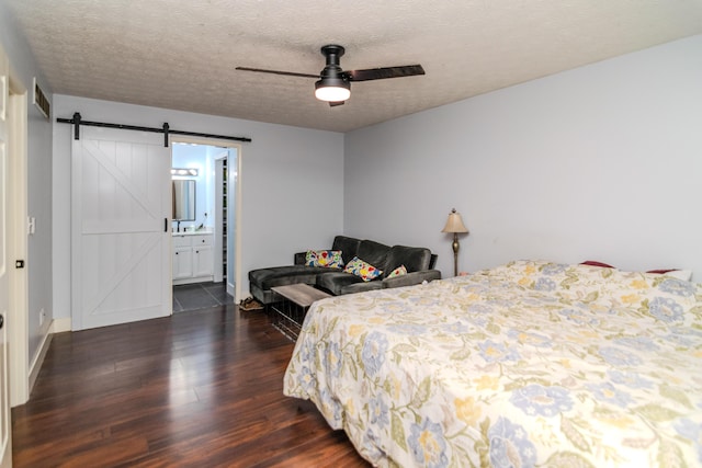 50 Barnett St, Hustonville, KY 40437 - bedroom with dark wood-style floors, a barn door, a textured ceiling, a ceiling fan, and ensuite bathroom