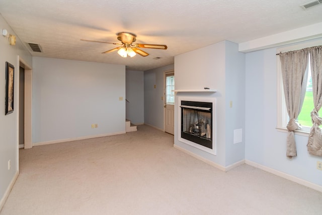 50 Barnett St, Hustonville, KY 40437 - unfurnished living room featuring light colored carpet, a ceiling fan, and a fireplace