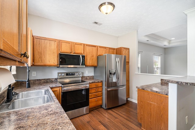 110 Seth Way, Georgetown, KY 40324 - kitchen with appliances with stainless steel finishes, dark wood-style flooring, a sink, brown cabinetry, and baseboards