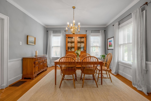 406 Dudley Rd, Lexington, KY 40502 - dining area with a chandelier, light wood-style flooring, plenty of natural light, crown molding, and wainscoting