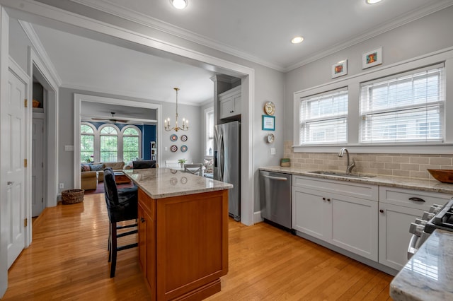 406 Dudley Rd, Lexington, KY 40502 - kitchen with appliances with stainless steel finishes, a sink, light wood-style flooring, a chandelier, and light stone counters