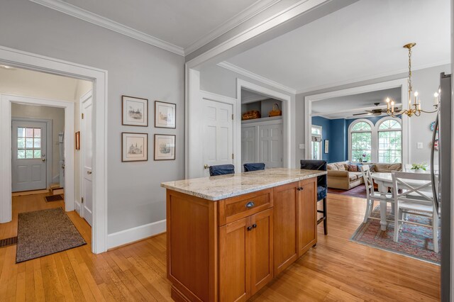 406 Dudley Rd, Lexington, KY 40502 - kitchen featuring a chandelier, light wood-style flooring, brown cabinets, light stone counters, and plenty of natural light
