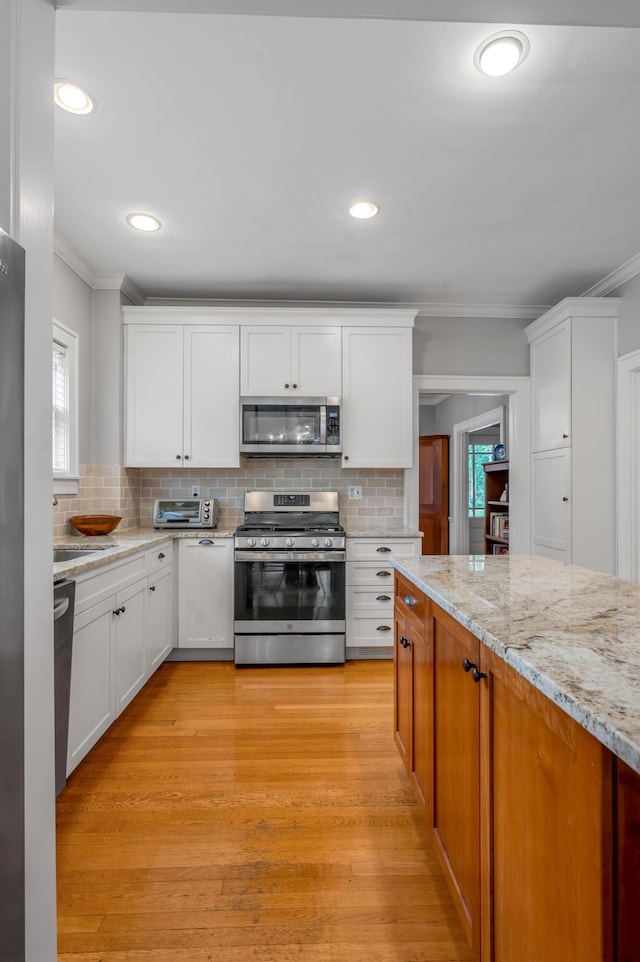 406 Dudley Rd, Lexington, KY 40502 - kitchen with appliances with stainless steel finishes, ornamental molding, white cabinets, decorative backsplash, and recessed lighting