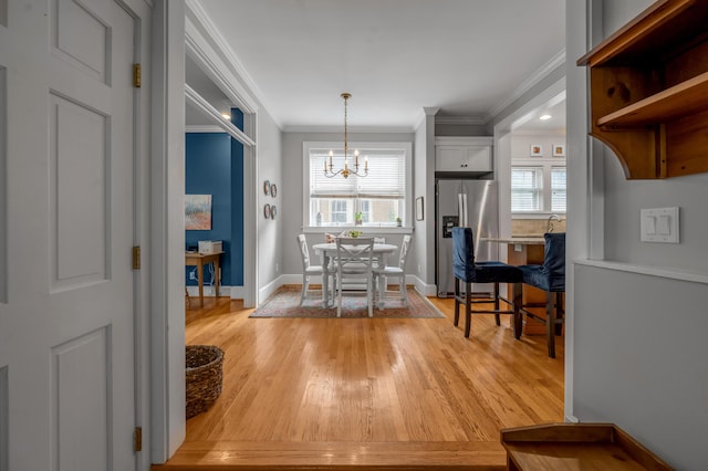 406 Dudley Rd, Lexington, KY 40502 - dining room with crown molding, light wood-type flooring, a chandelier, healthy amount of natural light, and baseboards