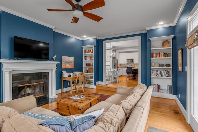 406 Dudley Rd, Lexington, KY 40502 - living area featuring a ceiling fan, wood finished floors, ornamental molding, built in shelves, and a premium fireplace