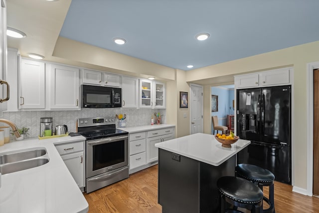 850 Charwood Dr, Lexington, KY 40515 - kitchen featuring black appliances, a sink, a kitchen bar, white cabinetry, and recessed lighting