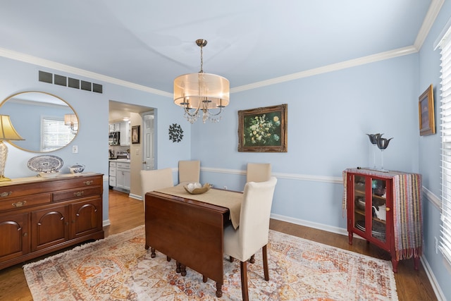 850 Charwood Dr, Lexington, KY 40515 - dining room with a chandelier, wood finished floors, crown molding, and baseboards