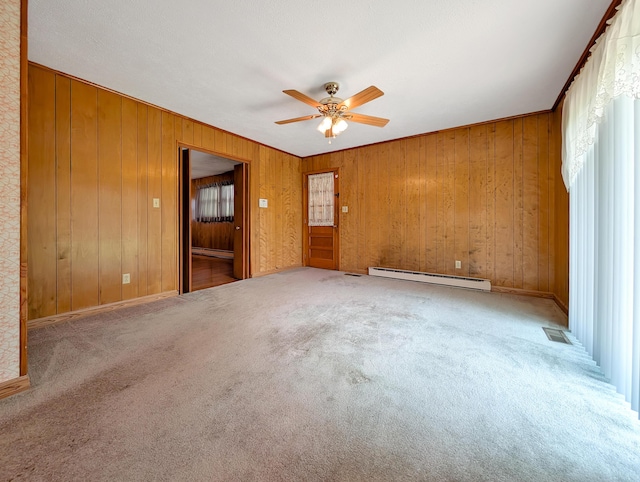 227 Mimosa Ave, Somerset, KY 42503 - carpeted empty room featuring a baseboard heating unit, ceiling fan, wooden walls, and baseboard heating