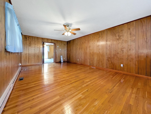 227 Mimosa Ave, Somerset, KY 42503 - spare room with a baseboard heating unit, light wood-type flooring, ceiling fan, wood walls, and baseboards